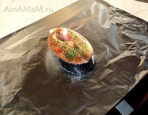 Стейк лосося, выложенный на фольгу и посыпанный пряными травами. Ожидает, пока его запеленают в фольгу. Стейк лосося, выложенный на фольгу и посыпанный пряными травами. Ожидает, пока его запеленают в фольгу.